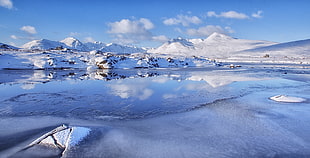 body of water and snow mountains during daytime