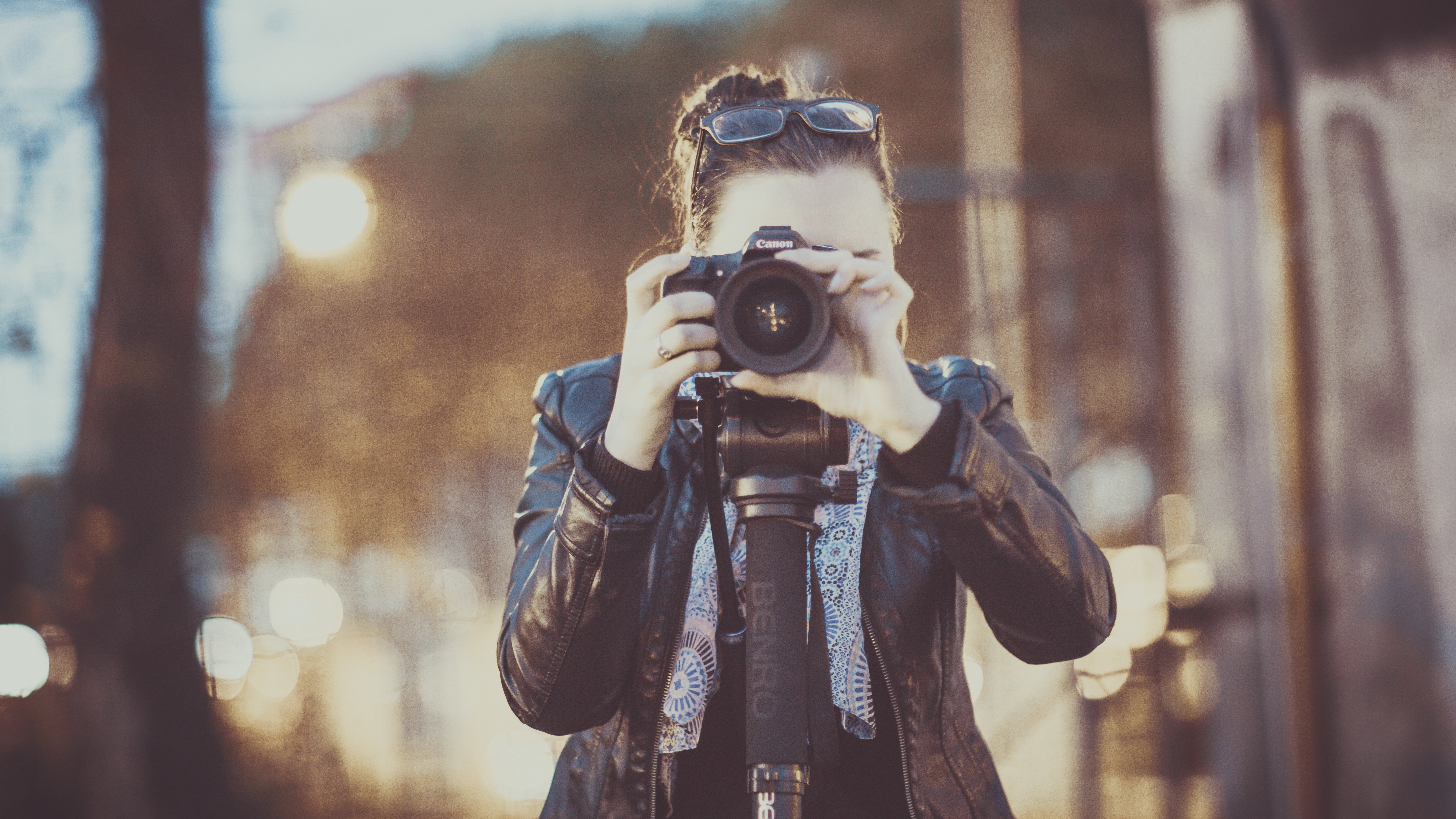 woman taking photo using black camera body at daytime
