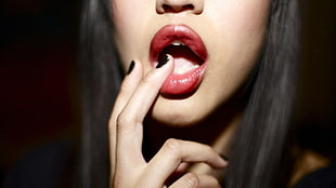 woman with red lipstick holding her lips photo
