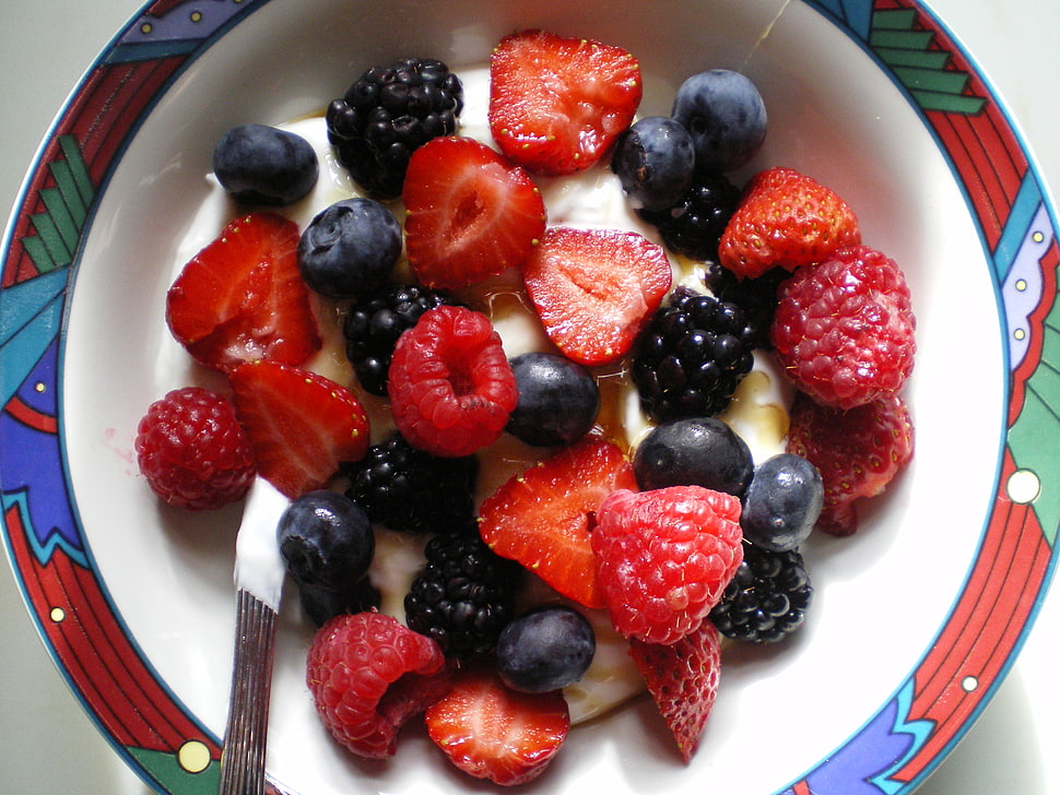 sliced strawberries and blueberries on white, red, and blue ceramic bowl with cream HD wallpaper