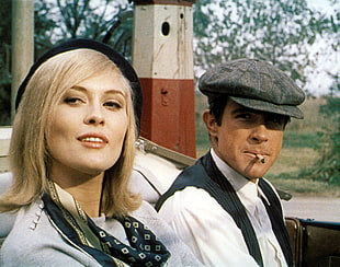 man in gray flatcap while smoking beside woman in black hat