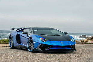 blue and black Lamborghini Gallardo parked on gray sand near ocean during daytime HD wallpaper