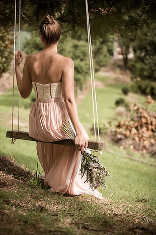 woman sitting on brown swing