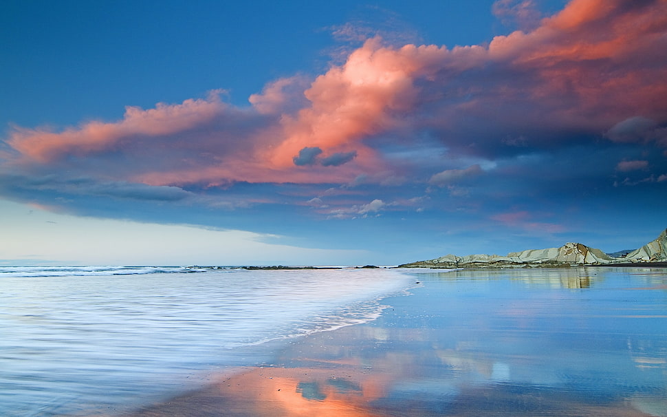 sea under orange and blue skies HD wallpaper
