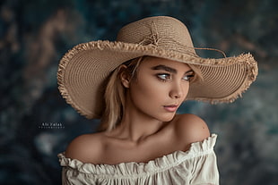 woman wearing white off-shoulder dress and brown hat
