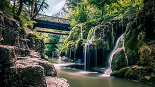 black metal bridge on green mountain with waterfalls HD wallpaper