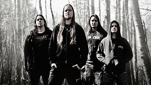 four man standing in front of trees with black hoodie jackets