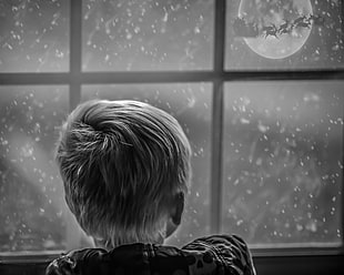 boy looking outside window during snow and Santa Claus riding sleigh HD wallpaper