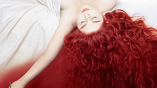 red haired woman lying on white textile