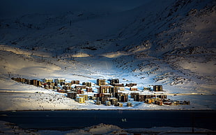 aerial photo of village on the foot of snowy mountain
