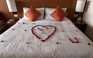 red flowers on bed forming heart