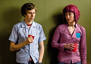 woman wearing pink dress shirt standing beside a man wearing blue button-up shirt