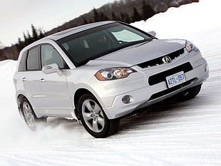 white Acura SUV on white snow field