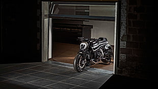 gray naked motorcycle parked on garage