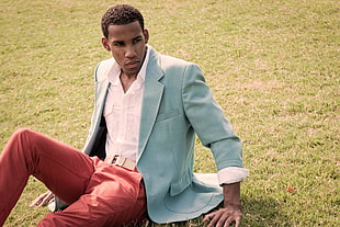 man in teal suit jacket and red dress pants sitting on green grass during daytime HD wallpaper