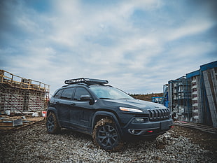 black Jeep SUV surrounded by blue steel scaffolding