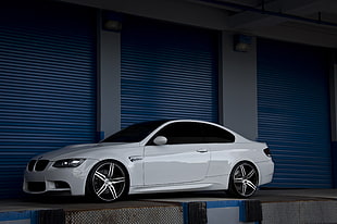 photo of white BMW coupe near roller shutter gate