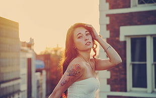 woman in white strapless top with shoulder tattoo