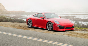 red Porsche 911 on dirt road