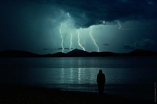 silhouette of human with thunders in the sky photography