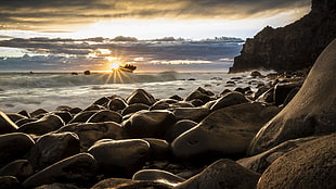 silhouette of stones on seashore surrounded with ocean waves