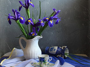 purple petaled flowers in white ceramic pitcher