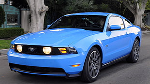 blue Ford Mustang on road during daytime