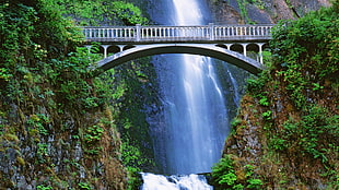 gray bridge with water fall during daytime