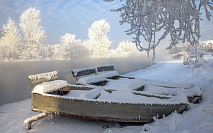 two snow covered brown wooden boat