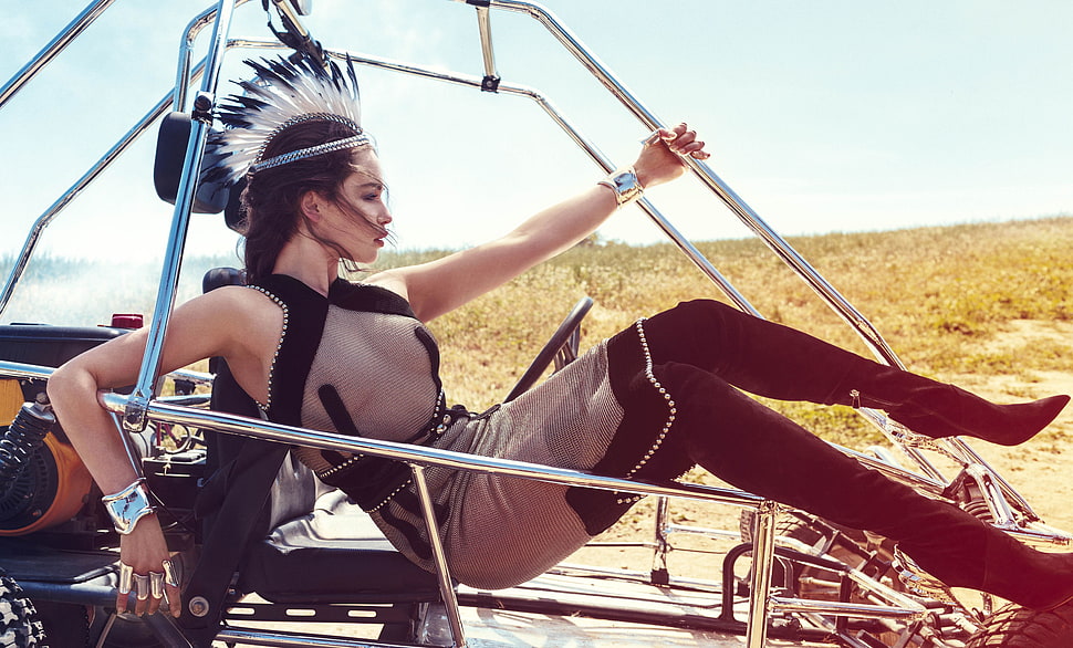 woman in gray see through halter top dress with black boots riding in dune buggy posing for photo during daytime HD wallpaper