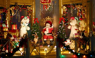 Santa Claus sitting on chair surrounded by Christmas decors