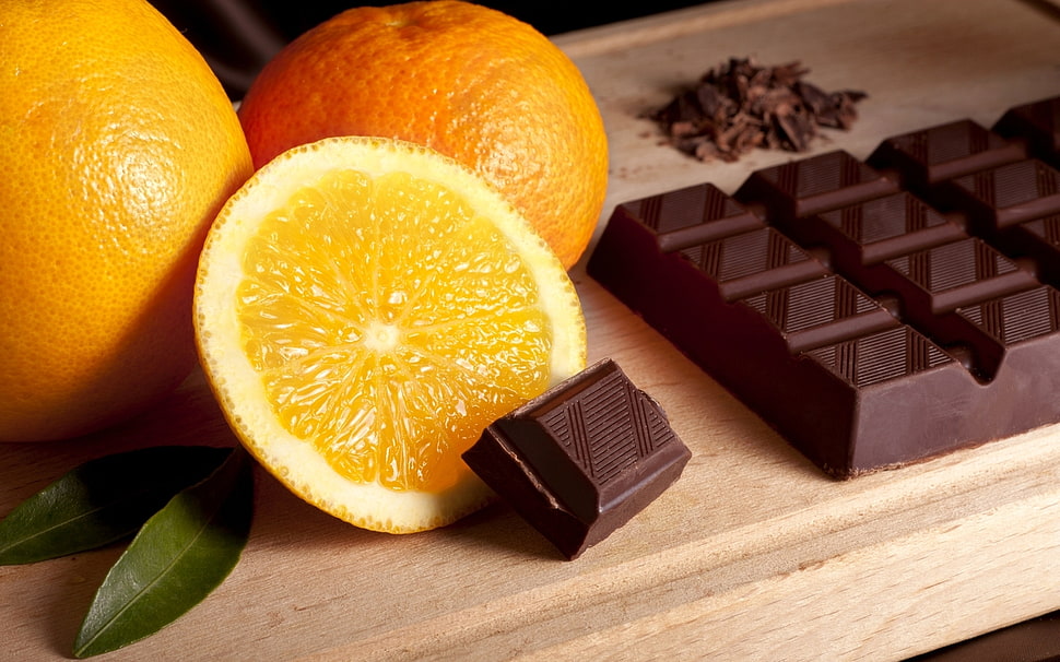 sliced orange citrus fruit beside chocolate bar closeup photography HD wallpaper