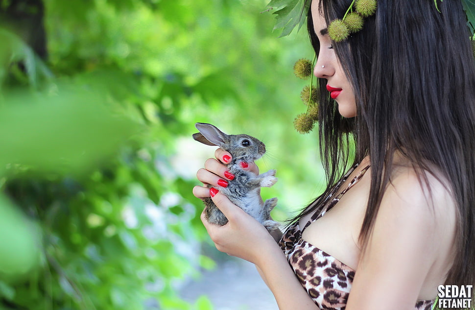 woman wearing brown and black leopard spaghetti strap top holding gray rabbit HD wallpaper