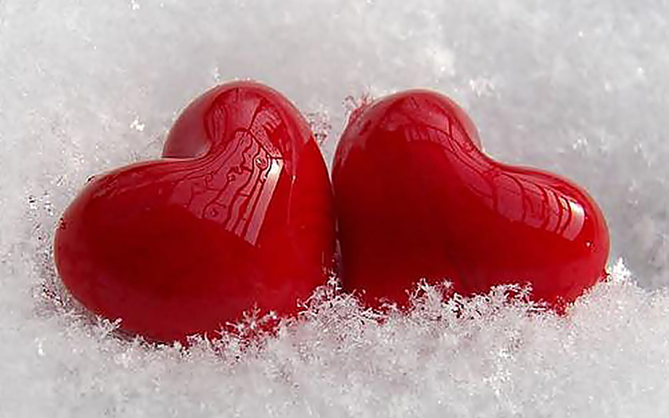 two red heart shaped ornaments lying on white surface HD wallpaper