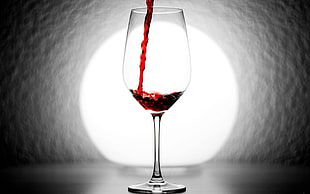 photo shallow focus photography of red liquid poured on clear wine glass