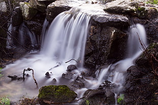 time lapse photography of water fountain with gray rocks HD wallpaper