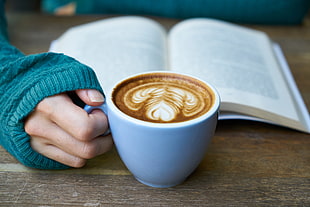 cafelatte in white ceramic mug on brown wooden table beside opened book HD wallpaper