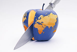 stainless steel kitchen knife slicing blue apple with map print HD wallpaper