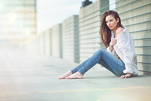 woman wearing long-sleeved shirt sitting barefoot on floor near wall HD wallpaper