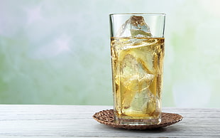 selective focus photography of clear highball glass with liquor and ice