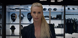 blonde haired woman in black top standing near glass display shelf