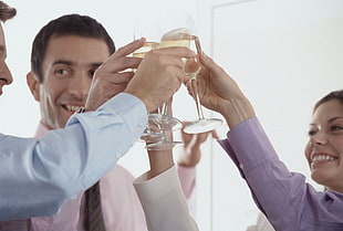 woman and man holding clear glass champagne flutes