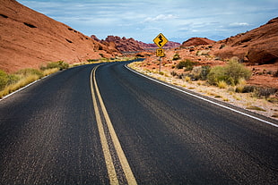landscape photography of road between desert hills