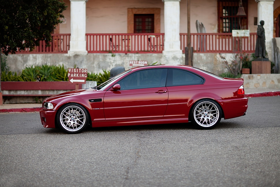 red sedan passing on gray road HD wallpaper