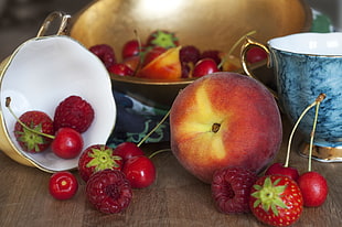 still life photography of red apple and strawberries on brown wooden surface