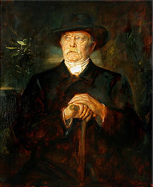 man wearing black coat holding cane portrait