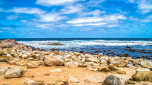 coastal rocks on shore under white and blue skies HD wallpaper