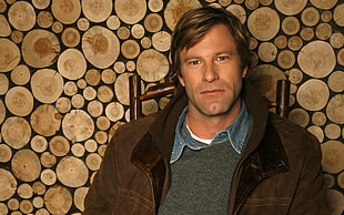 man in brown zip-up jacket sitting on chair HD wallpaper