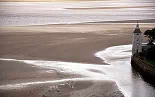 white lighthouse beside the beach