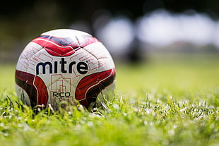 close up photo of white and red Mitre soccer ball